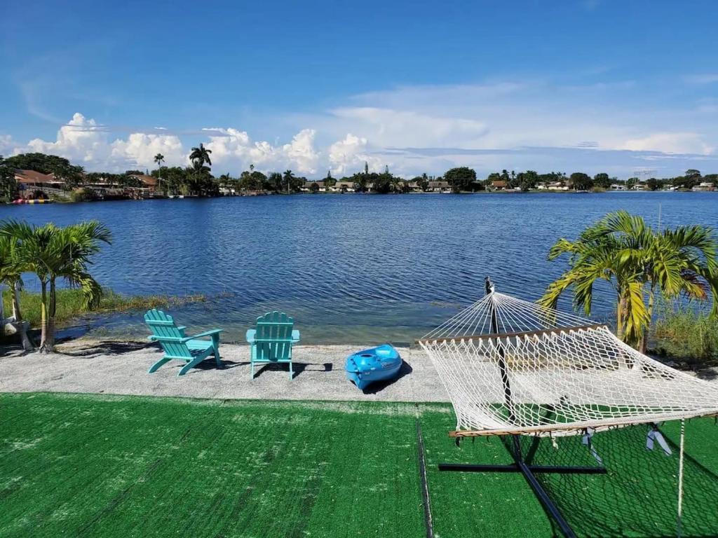 - un hamac et des chaises à côté d'une masse d'eau dans l'établissement Lakeside 3br Retreat With Private Yard & Kayak Use, à Fort Lauderdale
