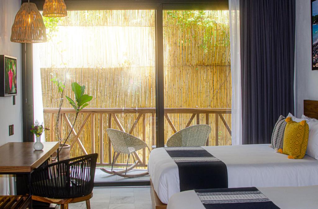 a hotel room with two beds and a balcony at Ximena Hotel Boutique in Sayulita