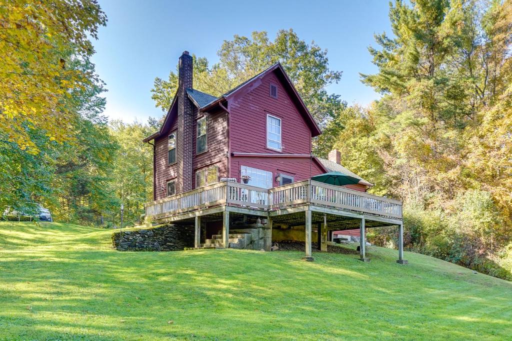 a large red house on a hill with trees at Tranquil 3 BR Stockbridge House with Private Deck! in Stockbridge