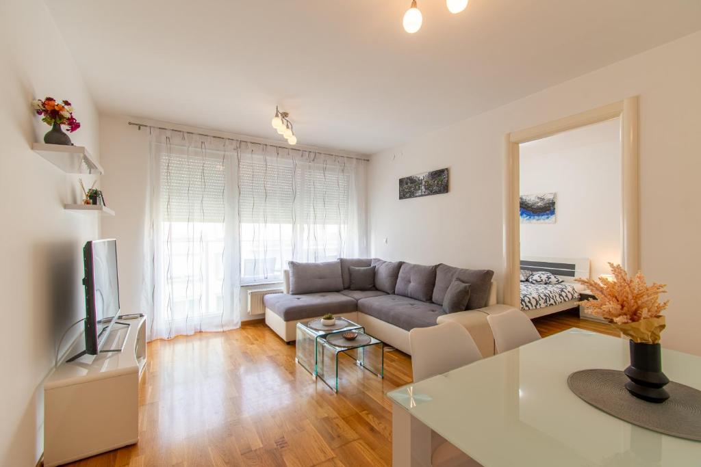 uma sala de estar com um sofá e uma mesa em Flexible SelfCheckIns 56 - Zagreb - Garage - Loggia - New em Zagreb