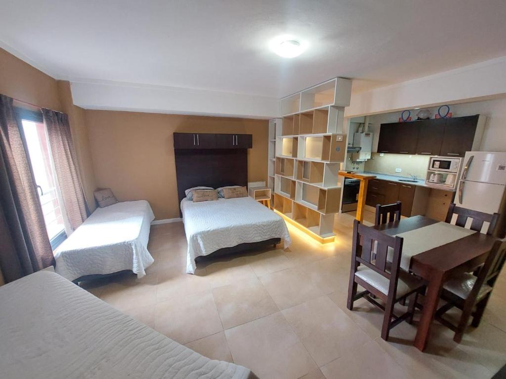 Una pequeña habitación con dos camas y una cocina. en departamentos lasserre, en Río Grande