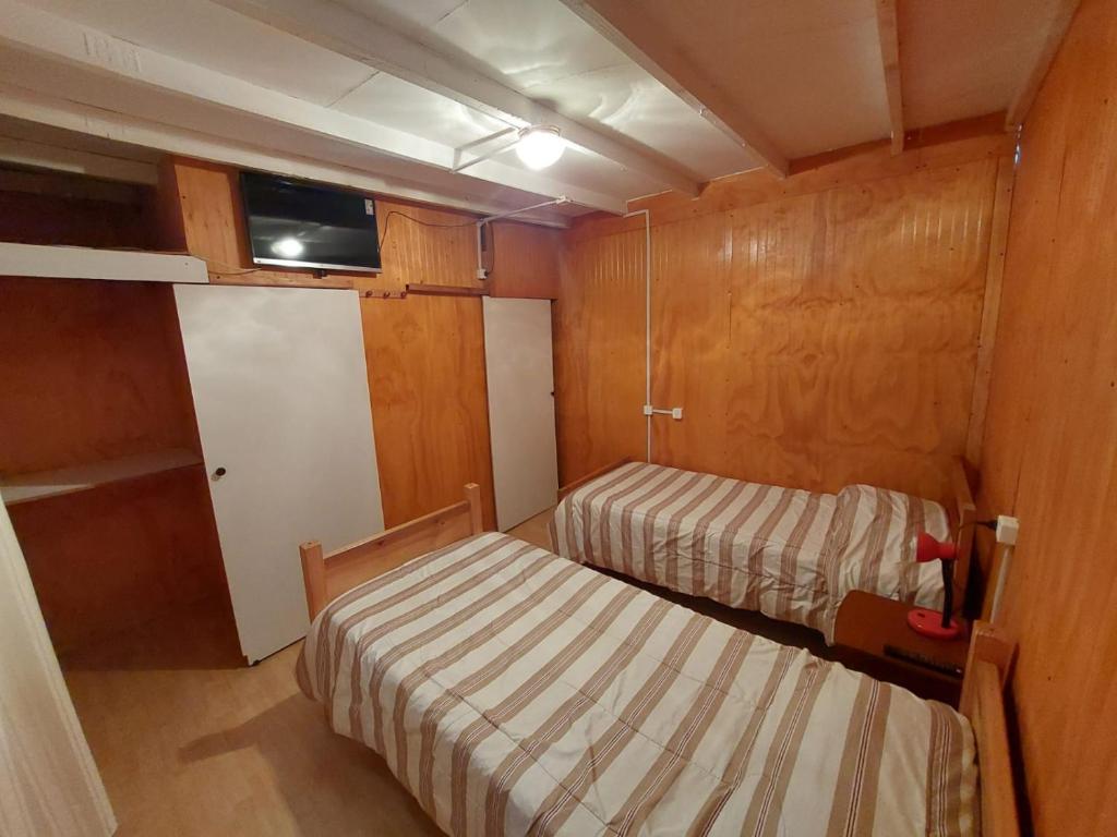 - une petite chambre avec 2 lits dans l'établissement Residencial RO, à Copiapó