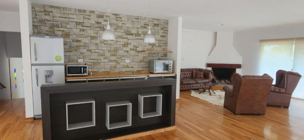 uma sala de estar com uma cozinha e uma sala de estar com uma lareira em Casa en Raco em San Miguel de Tucumán