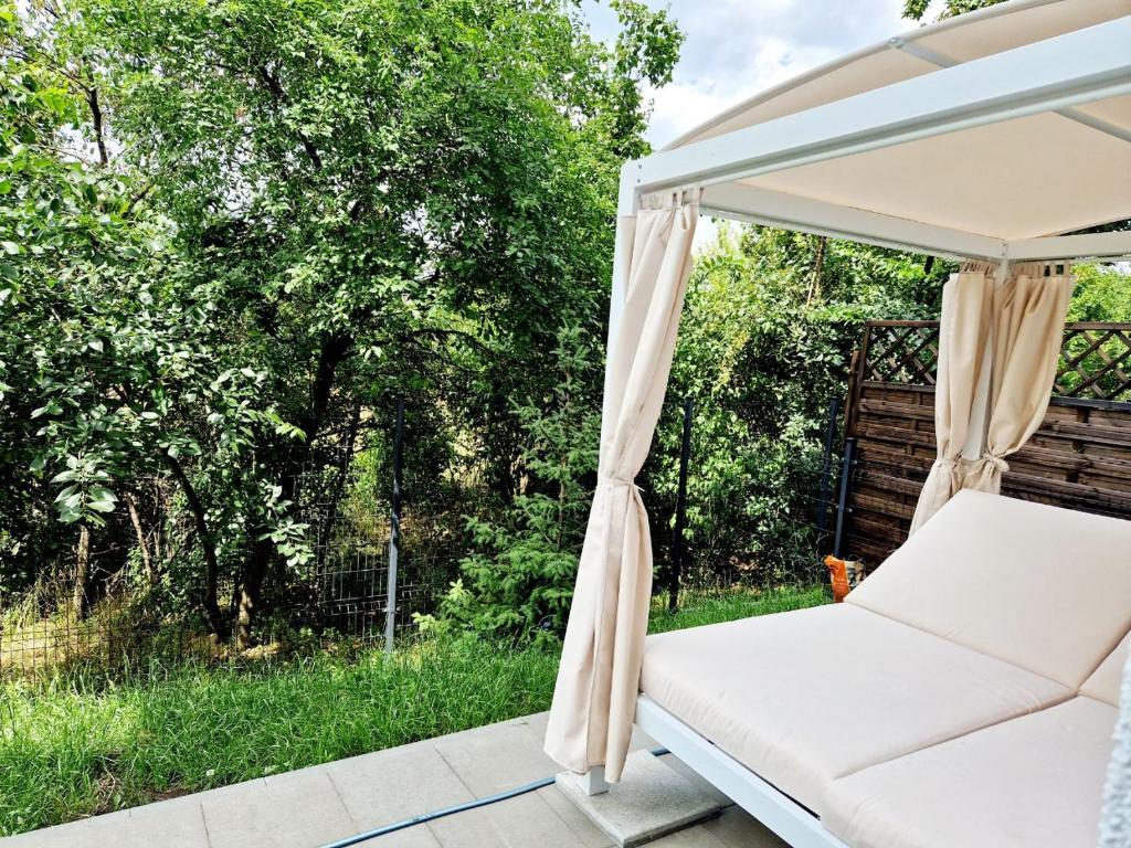 un letto a baldacchino bianco su un patio alberato di Comfortable flat with garden a Poznań