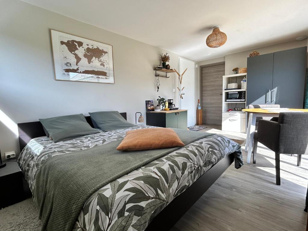 a bedroom with a bed and a desk and a kitchen at Le Cottage de l'Albâtre Gîte 2 pers jardin parking 6 kms Etretat Yport in La Forge