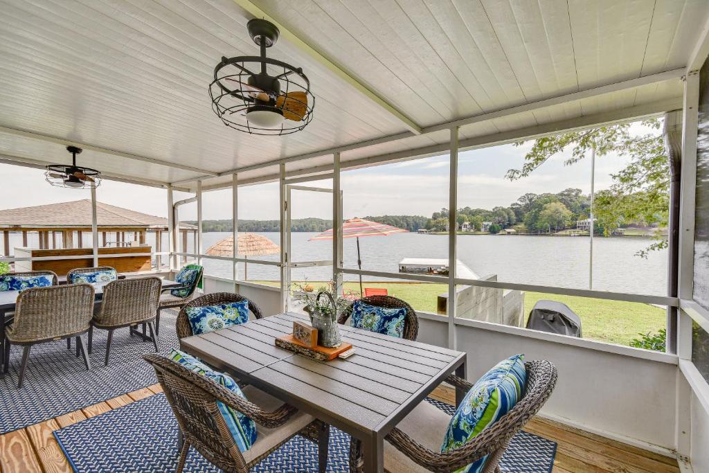 a porch with a table and chairs and a view of the water at Lake Martin Retreat with Private Dock and Boat Launch in Dadeville