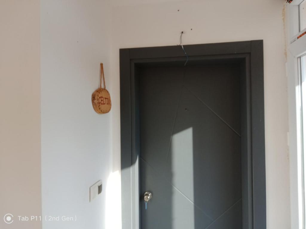 una porta nera con un orologio sul muro di rainfort apart nikfer 