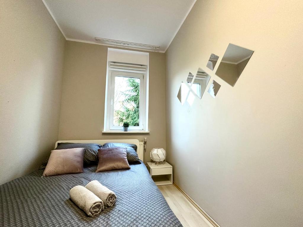 sypialnia z łóżkiem z poduszkami i oknem w obiekcie MMRent Plant Room w Gdańsku