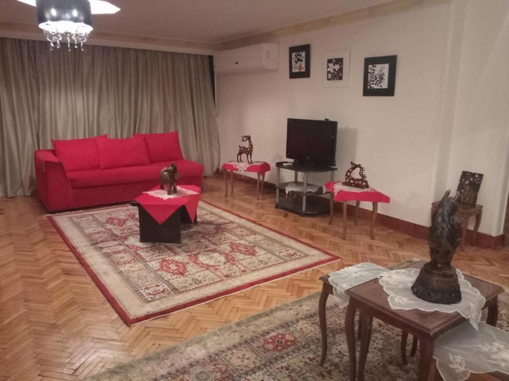 - un salon avec un canapé rouge et une télévision dans l'établissement zamalek, au Caire