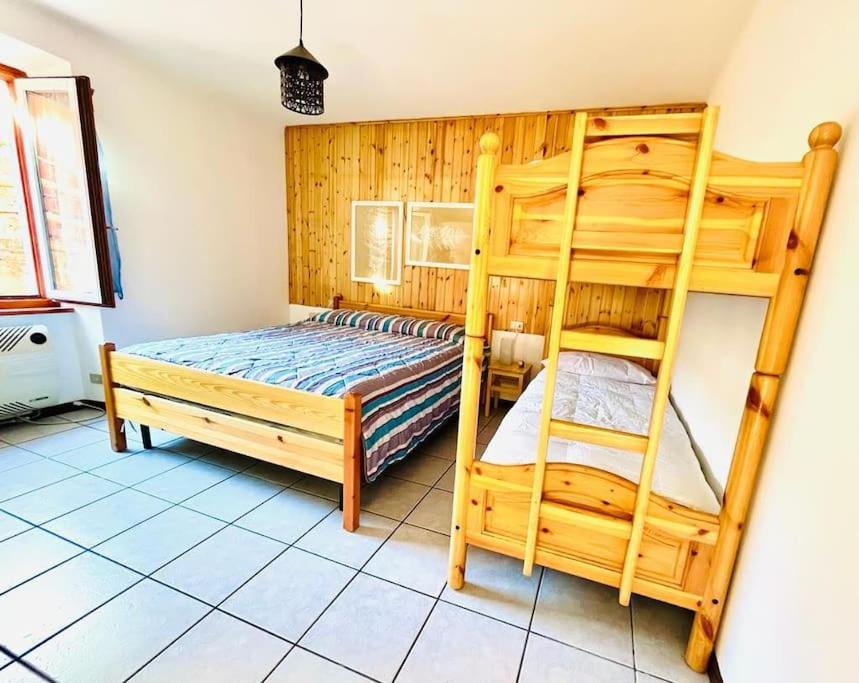 een slaapkamer met 2 stapelbedden en een ladder bij Luminoso in centro paese in Carona