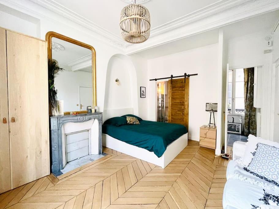 - une chambre avec un lit vert et un miroir dans l'établissement Brand new Flat in Paris, à Paris