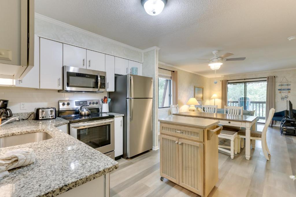 a kitchen with white appliances and a dining room at Walk to Beach Hilton Head Condo with Balcony in Hilton Head Island
