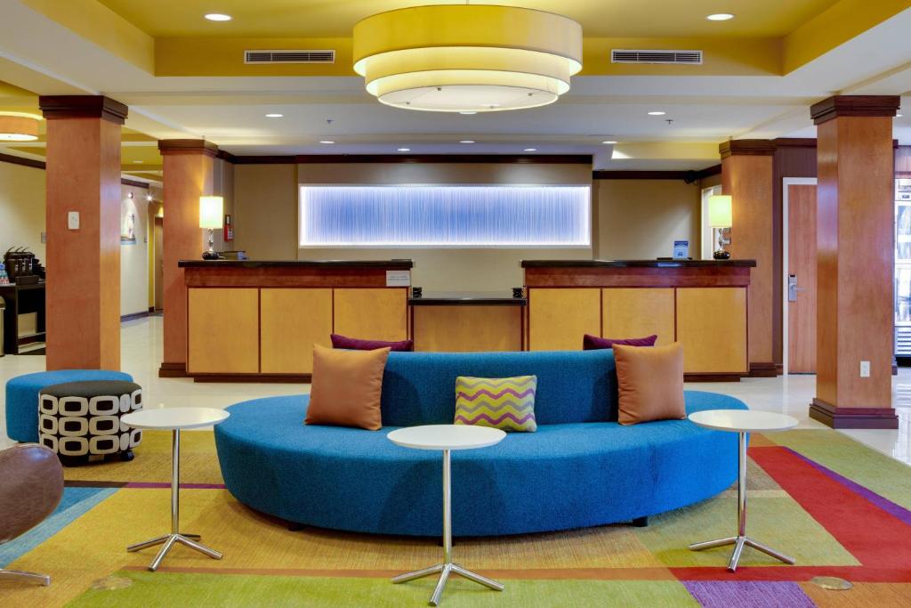 a living room with a blue couch and tables at Fairfield Inn and Suites by Marriott Titusville Kennedy Space Center in Titusville