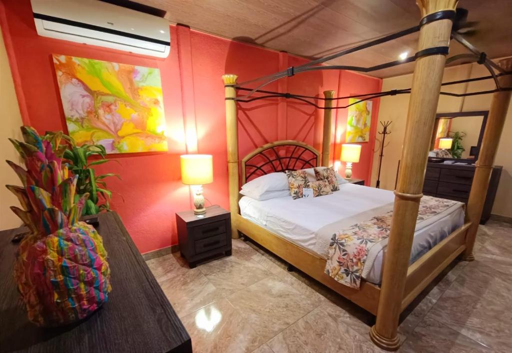 a bedroom with a four poster bed and a table at Suite Paraiso Azul in Tamarindo