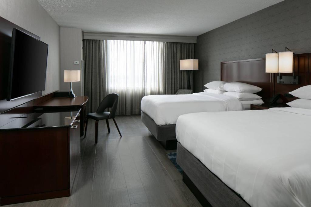 a hotel room with two beds and a flat screen tv at West Des Moines Marriott in West Des Moines