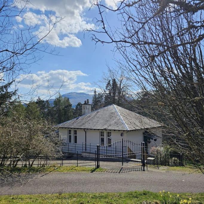 a white house with a fence in front of it at Scottish Highland Cottage Tyndrum Upper Station in Crianlarich
