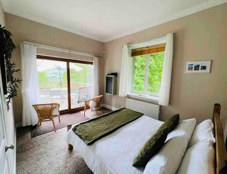 ein Schlafzimmer mit einem großen Bett und einem großen Fenster in der Unterkunft Scottish Highland Cottage Tyndrum Upper Station in Crianlarich