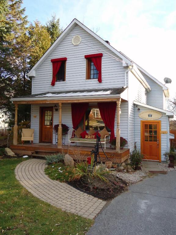 a white house with red drapes on it at Auberge Old Chelsea in Chelsea