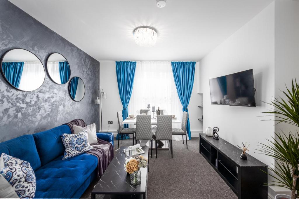 ein Wohnzimmer mit einem blauen Sofa und einem Tisch in der Unterkunft Cosy 4-Bedroom Apartment next to Borough in London