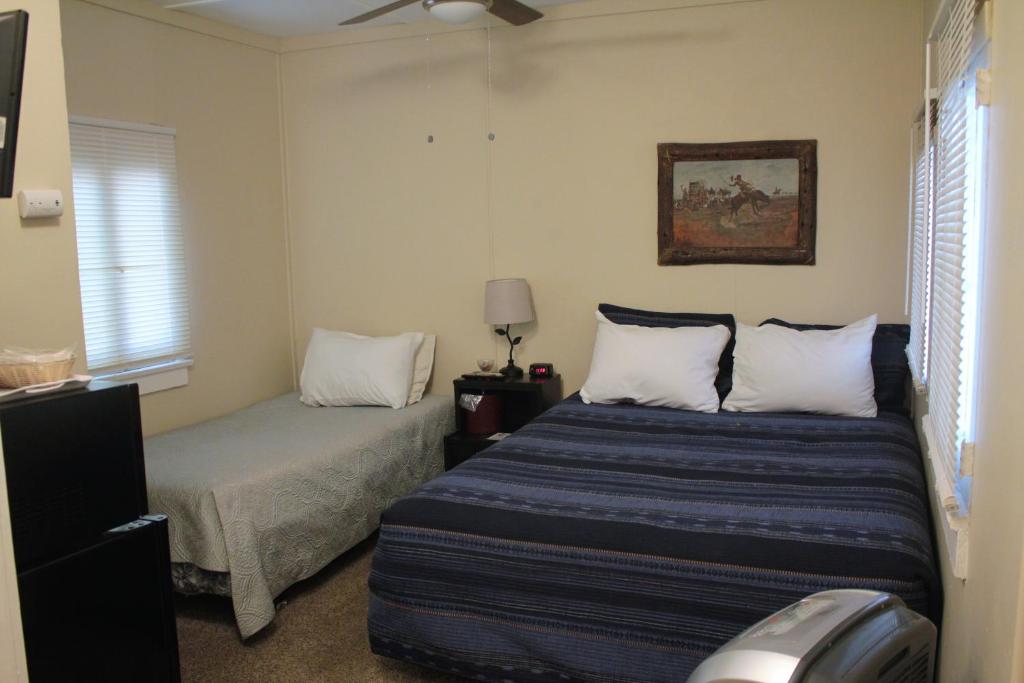 1 dormitorio con 2 camas y ventilador de techo en Grand Canyon West Hotel Sheps Miners Inn, en Chloride