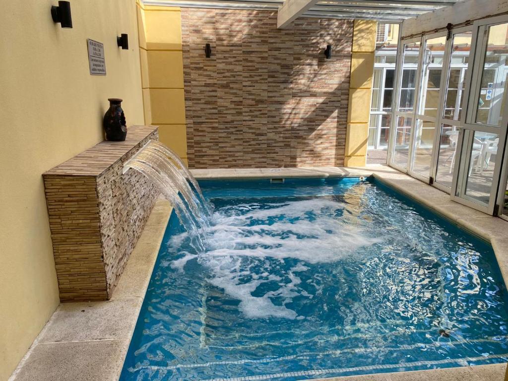 a pool with a water fountain in a building at Hotel Gran Lido in Santa Teresita