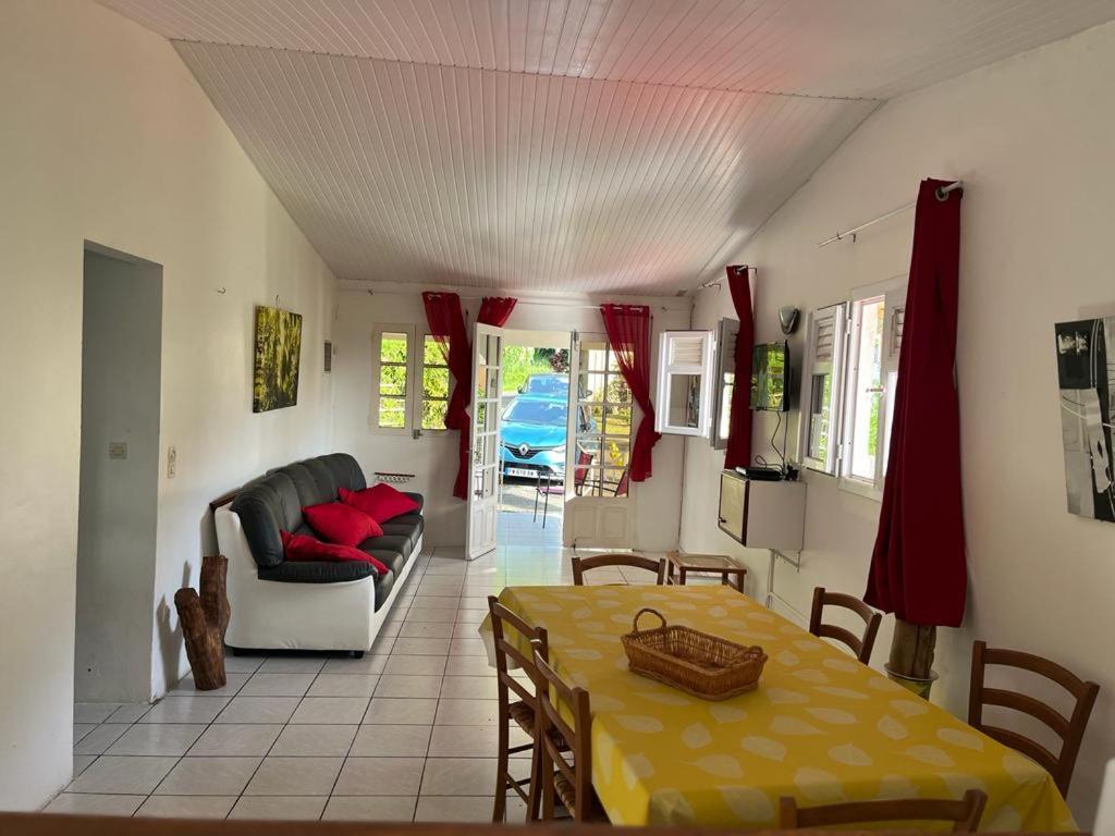 een woonkamer met een tafel en een bank bij La Villa Les Cythos 1 in Le Lamentin