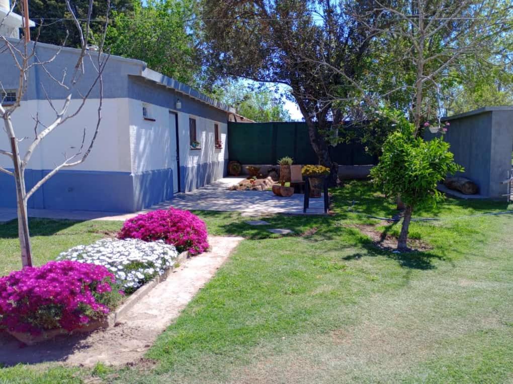 a yard with pink flowers and a fence at La Aldea in Rodeo de la Cruz