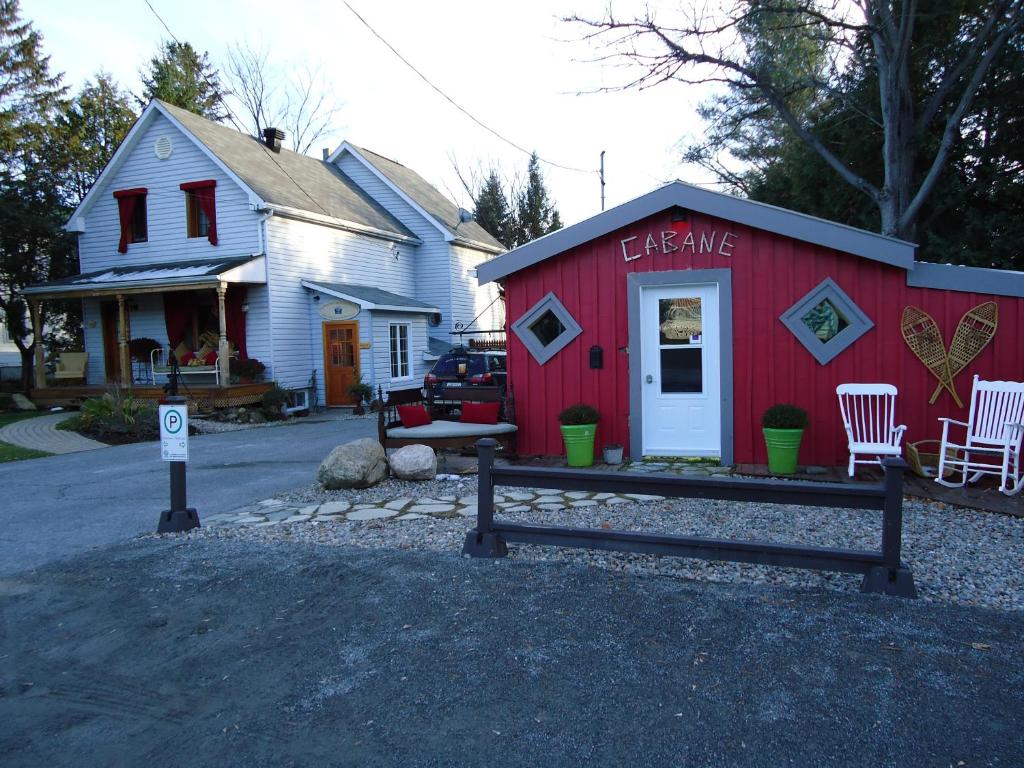 a red shed with a bench in front of a house at Auberge Old Chelsea in Chelsea