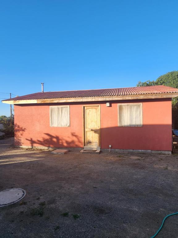 uma casa vermelha e laranja com garagem em Cabaña Amapola, Pichidangui em Pichidangui