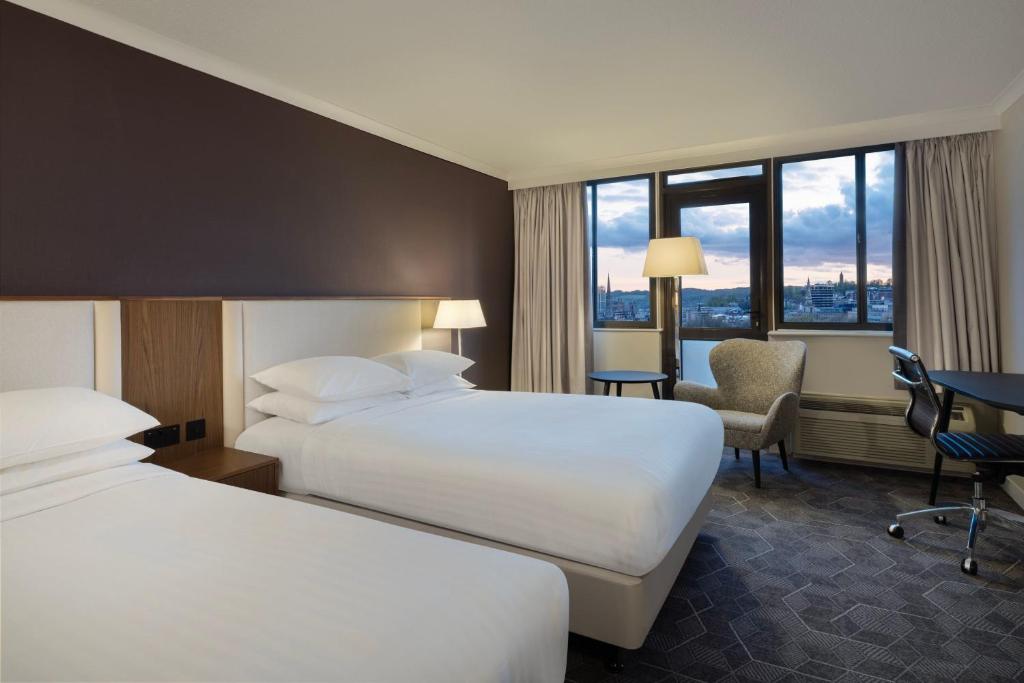 ein Hotelzimmer mit 2 Betten und einem Stuhl in der Unterkunft Delta Hotels by Marriott Bristol City Centre in Bristol