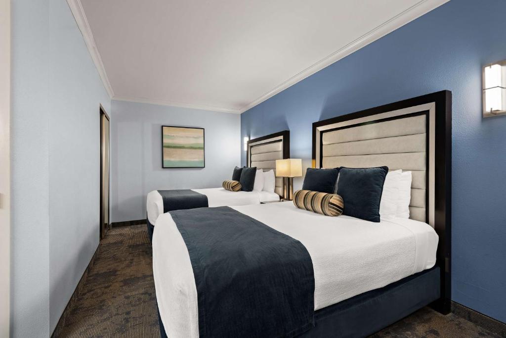 two beds in a room with blue walls at Best Western Plus Manhattan Beach Hotel in Manhattan Beach