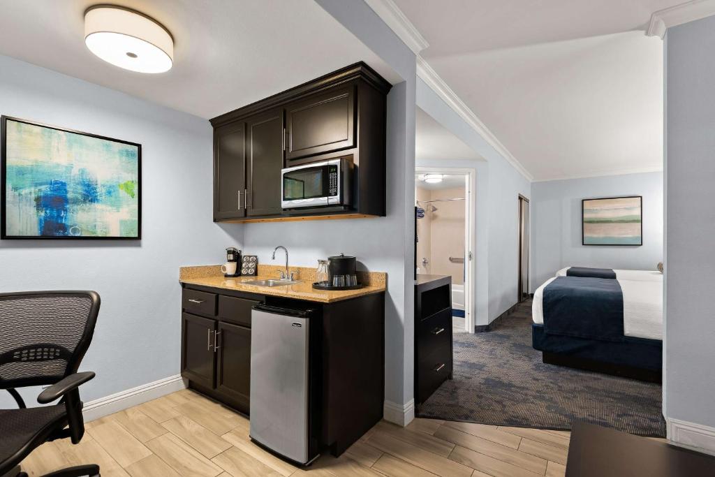 a room with a kitchen and a bedroom with a bed at Best Western Plus Manhattan Beach Hotel in Manhattan Beach