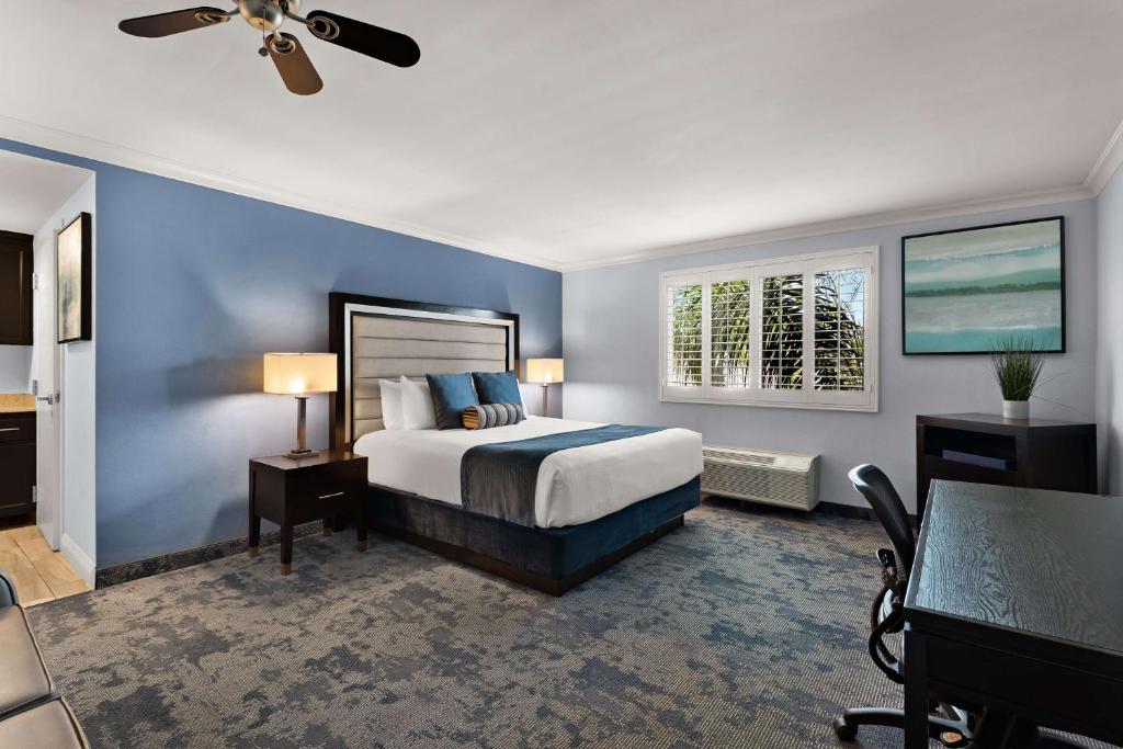 a bedroom with a bed and a blue wall at Best Western Plus Manhattan Beach Hotel in Manhattan Beach