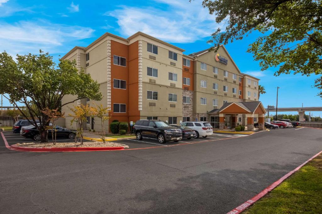 un hotel con coches estacionados en un estacionamiento en Comfort Inn & Suites ATX North, en Austin