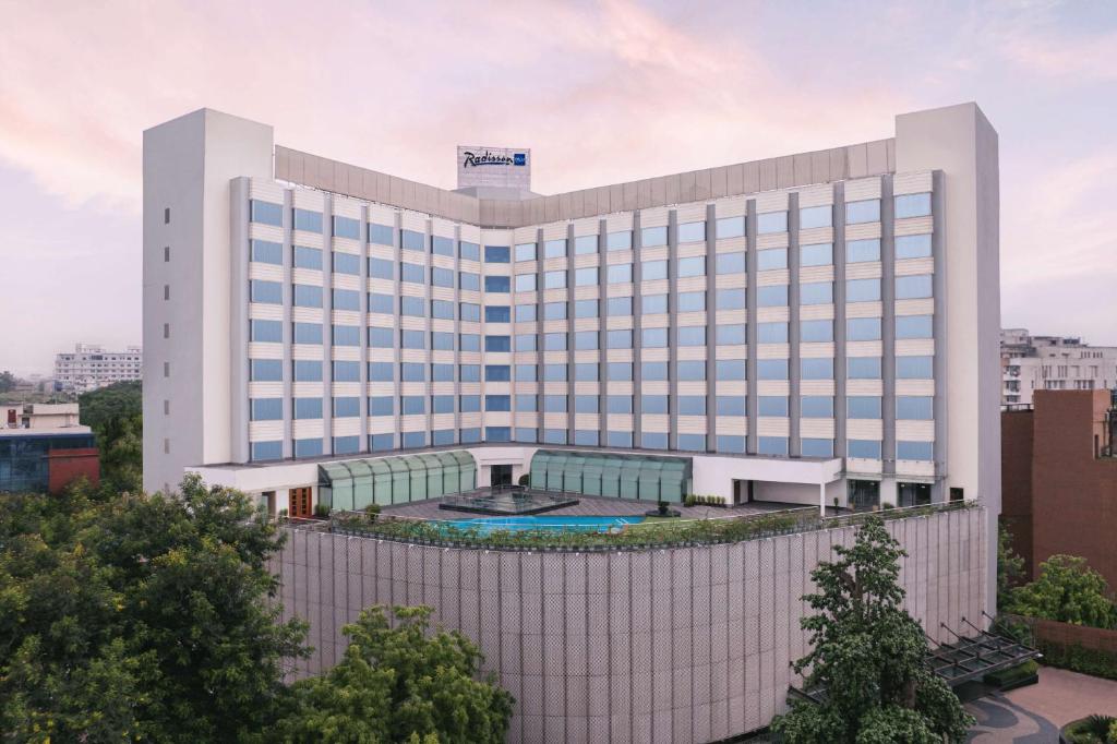 a large white building with a pool in front of it at Radisson Blu Hotel Ranchi in Rānchī