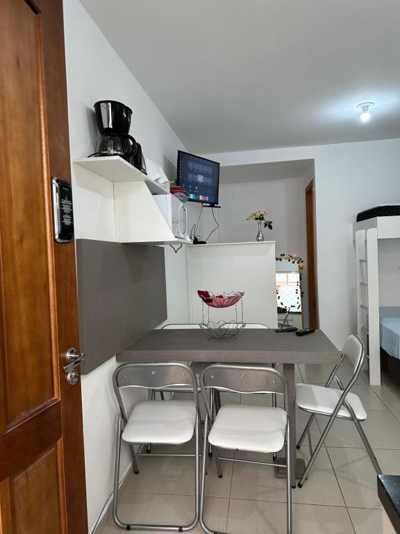 a small kitchen with a table and four chairs at Apartamento studio térreo in Balneário Camboriú