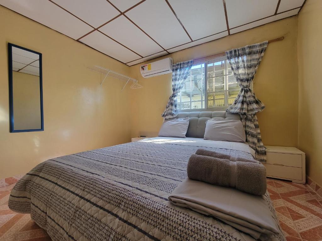 a bedroom with a large bed with a window at Chelox Panama Airport in Tocumen