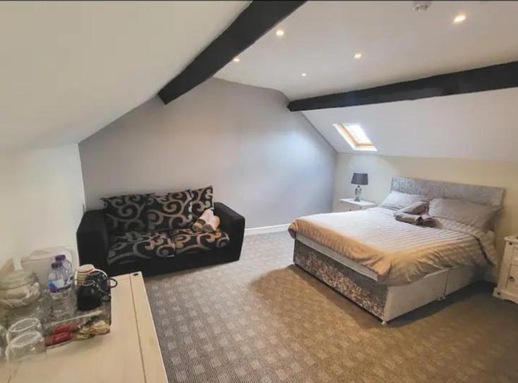 a bedroom with a large bed and a couch at The dublin packet family room in Holyhead