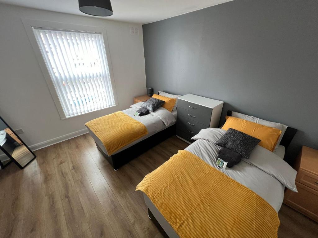 a bedroom with two beds and a window at Leeds Serviced Accommodation in Killingbeck