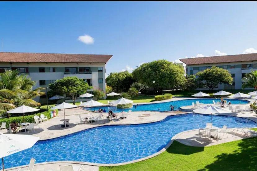 uma vista superior de um resort com uma grande piscina em Flat Super Luxo Carneiros Beach Resort em Tamandaré