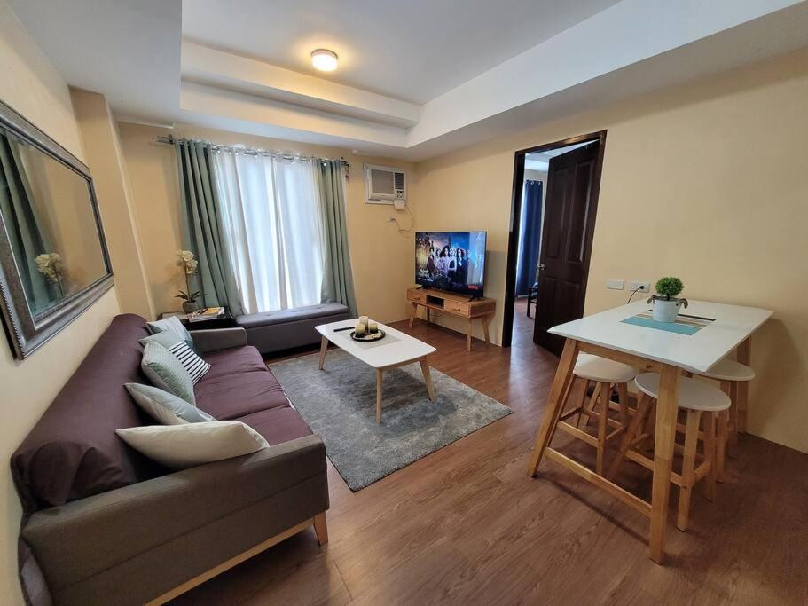 a living room with a couch and a table at 1 BR Condo in East BelAir Residence Cainta Rizal with parking in Manila