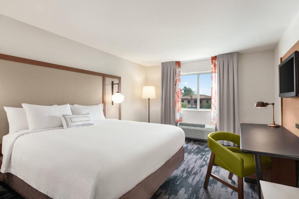 een hotelkamer met een bed, een stoel en een raam bij Fairfield Inn by Marriott Visalia Sequoia in Visalia