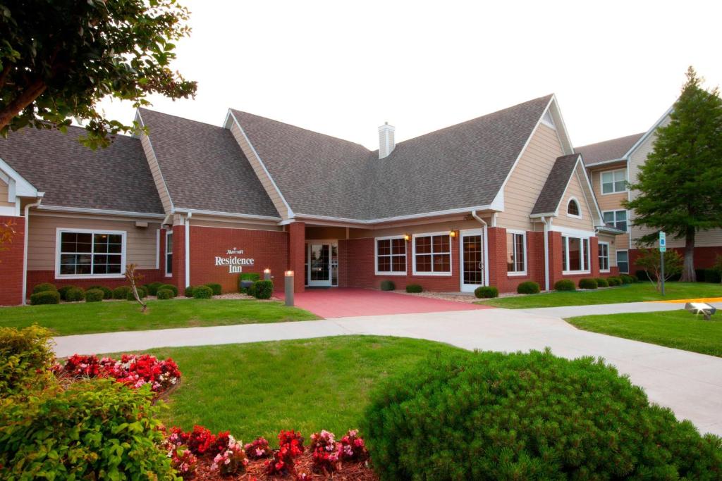 a large red building with flowers in front of it at Residence Inn by Marriott Oklahoma City South in Oklahoma City