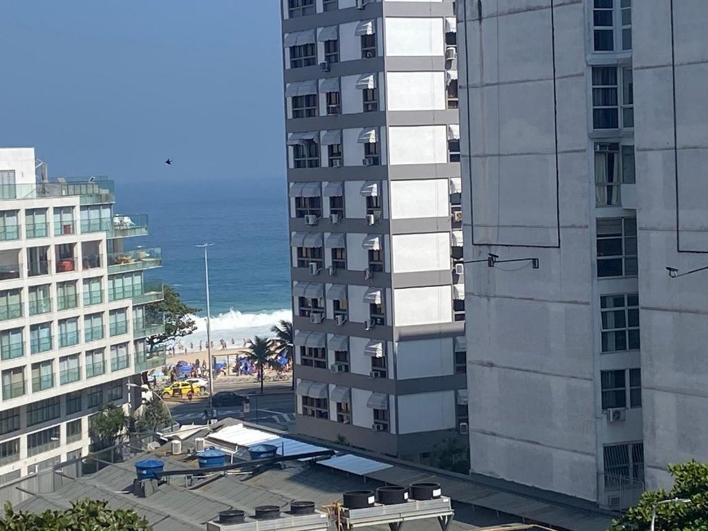 uma vista de um edifício e do oceano a partir de um edifício em Três suítes há poucos passos da praia no Rio de Janeiro