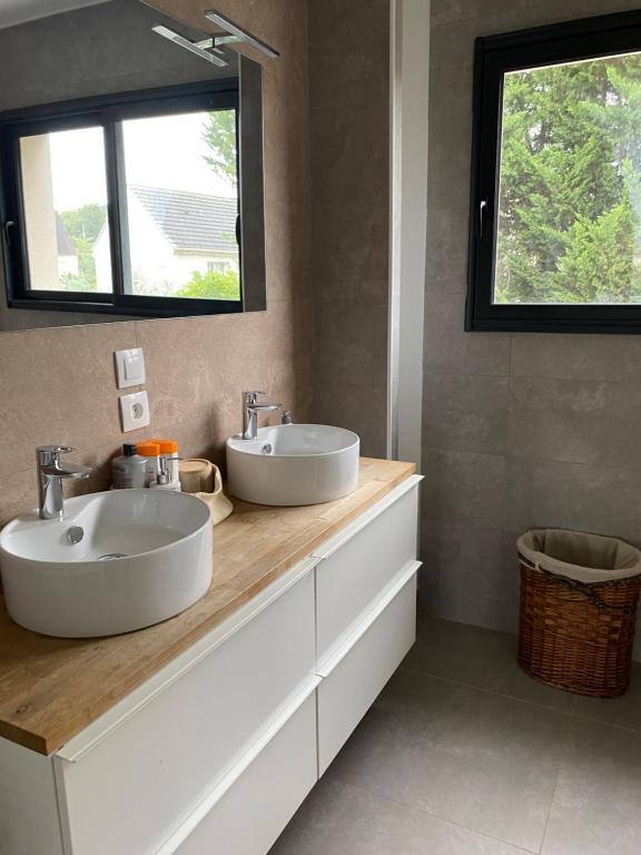 La salle de bains est pourvue de 2 lavabos et d'un miroir. dans l'établissement Chambre chaleureuse avec une vue dégagée, à La Frette-sur-Seine