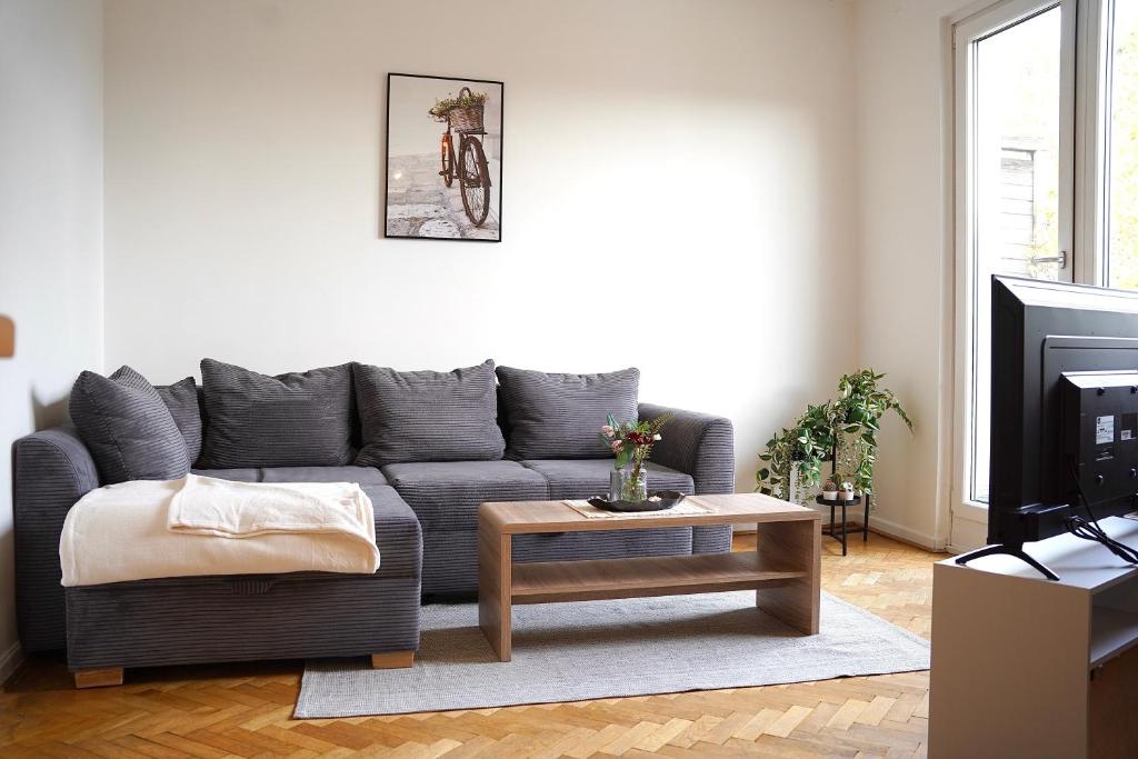 ein Wohnzimmer mit einem grauen Sofa und einem Couchtisch in der Unterkunft *TOP Apartment* beliebte Lage* in Düsseldorf in Düsseldorf
