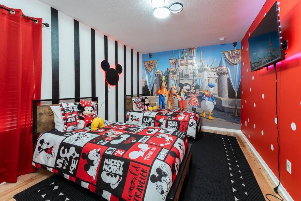 a bedroom with two beds and a disney mural at The Dream Vacation Home! in Orlando