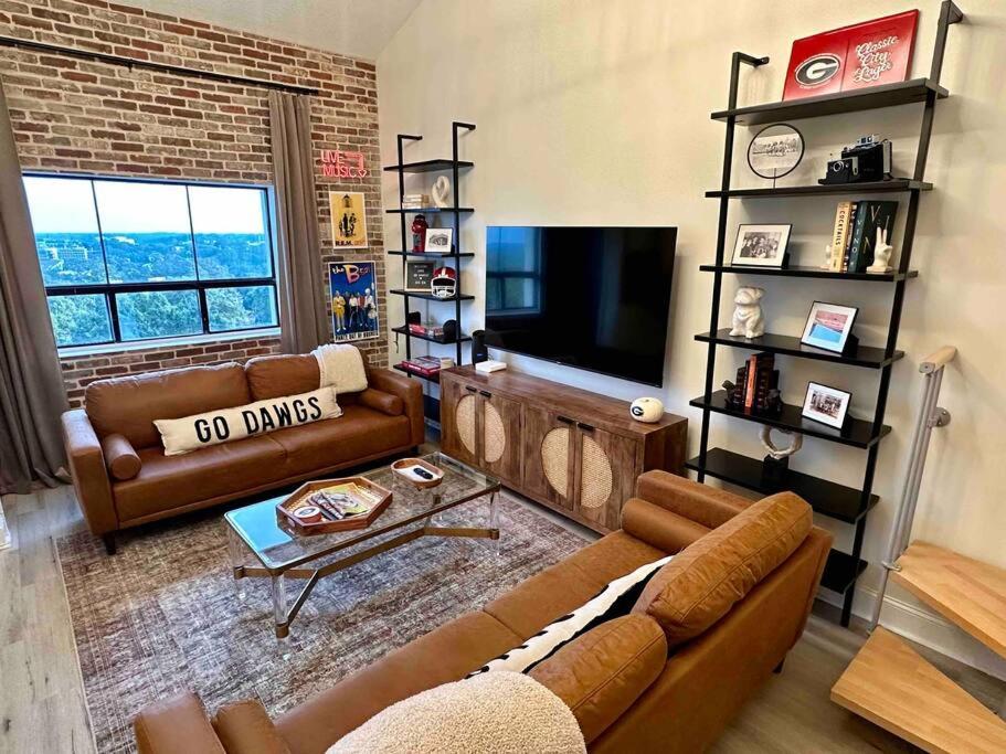 uma sala de estar com dois sofás e uma televisão em UGA Penthouse Downtown Athens Walk To Stadium em Athens