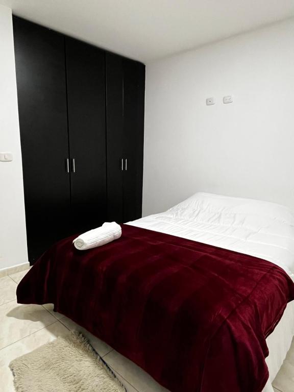 Un dormitorio con una cama con una manta roja. en Apartamento pitalito, en Pitalito