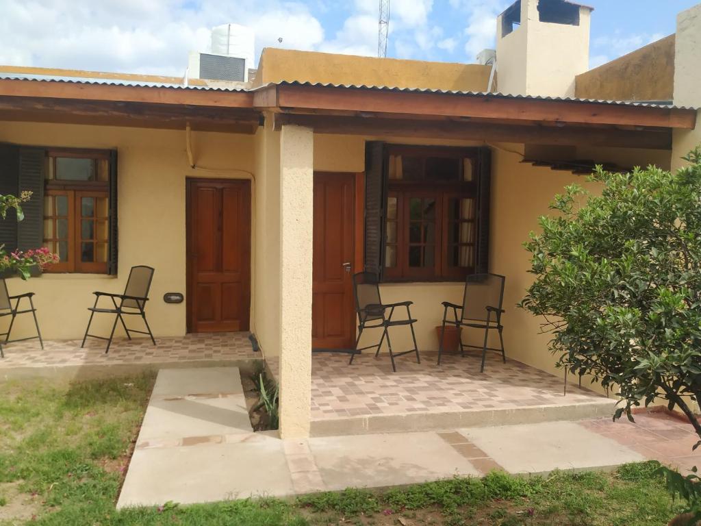 a house with chairs and tables in front of it at Departamentos Centro in Villa Dolores